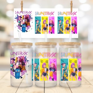 May include: Glass beverage cups with wooden lids and straws, featuring a colourful graphic design with the word "UNTRX" and illustrations of characters. A matching print is clipped above the cups.