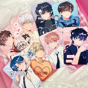 May include: A collection of rectangular anime-style character cards featuring various individuals with diverse hair colours and outfits. The cards display graphic illustrations with decorative elements like hearts, speech bubbles, and text including LOVE UYUN, UYUN, and hyung.