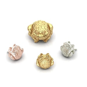May include: Four frog figurines in different sizes and colors. The largest frog is gold, the next largest is gold, the next smallest is rose gold, and the smallest is silver.