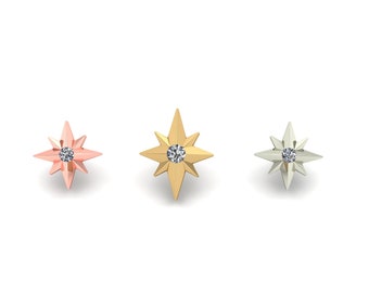May include: Three star-shaped stud earrings in rose gold, gold, and silver, each with a central clear gemstone. The earrings are displayed against a white background, showcasing their geometric design and varying metallic finishes.