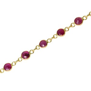Pode incluir: Uma delicada pulseira de corrente dourada com uma série de pedras preciosas redondas, vermelho escuro. As pedras preciosas são espaçadas uniformemente e colocadas em biséis de ouro individuais, criando um visual refinado e elegante.
