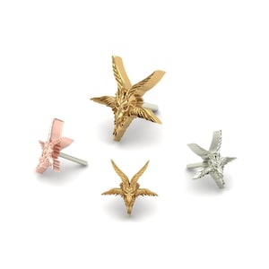 Può includere: Quattro orecchini a forma di stella a cinque punte con un design a testa di capra, in oro, argento e oro rosa.