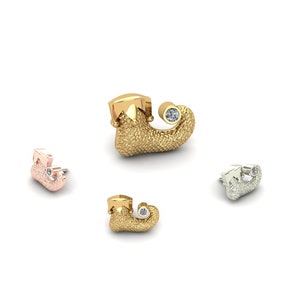 Könnte beinhalten: Drei Elfen-Schuh-Ohrringe in Gold, Silber und Roségold, jeder mit einem kleinen, klaren Edelstein.