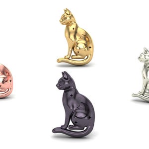 May include: Four cat figurines in different metallic finishes: rose gold, gold, silver, and dark gray. Each cat is in a seated position with star-shaped cutouts. The background is plain white.