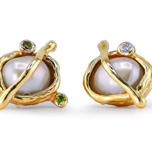 May include: A pair of gold earrings with a pearl, a green gemstone, and a clear gemstone.