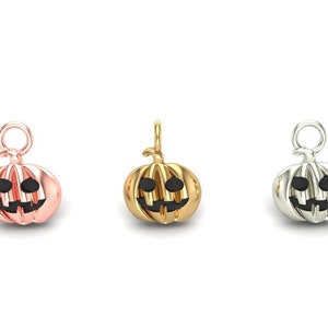 Puede incluir: Tres abalorios de calabaza en diferentes acabados metálicos: oro rosa, oro y plata. Cada abalorio presenta una cara de calabaza con ojos negros y una amplia sonrisa.