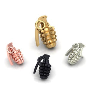 May include: Four grenade-shaped charms in different colours: gold, rose gold, silver and black. The charms are detailed with a pin and a handle.