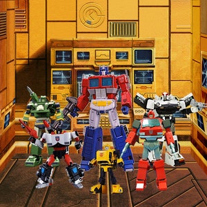 May include: A group of six Transformers action figures, including Optimus Prime, Bumblebee, and Ironhide, standing in a yellow and brown room with a control panel in the background.