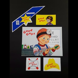 May include: A set of Good Guys stickers featuring a red-haired boy with a stethoscope, a star with the words "Good Guys" inside, and a baseball bat with the words "Good Guys" on it. The stickers are on a black background.