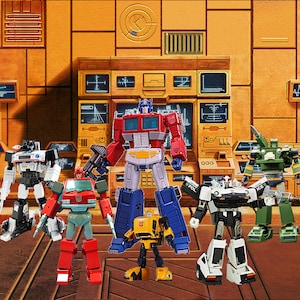May include: A group of six Transformers action figures, including Optimus Prime, Bumblebee, and Ironhide, standing in front of a yellow and brown control panel. The figures are made of plastic and have articulated limbs.