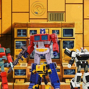 May include: Five Transformers action figures in a futuristic setting. The figures are Optimus Prime, Bumblebee, Ironhide, Prowl, and Starscream. The figures are all in their robot modes and are posed in a variety of action poses.