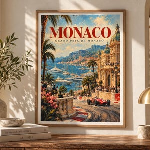 May include: A framed wall art print featuring a vintage-style painting of the Monaco Grand Prix. The image displays a red race car on a coastal track, a grand building, palm trees, and yachts in the blue sea, with the text MONACO GRAND PRIX DE MONACO.