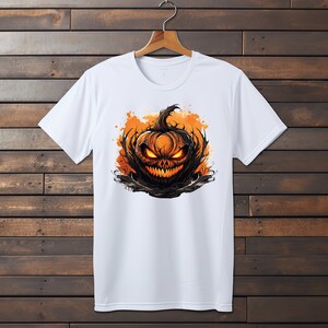 Puede incluir: Camiseta blanca con un estampado gr&aacute;fico de una calabaza de Halloween aterradora con ojos brillantes y una sonrisa amenazante.