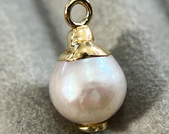 May include: A gold-toned pearl charm with a loop for attaching to a necklace or bracelet.