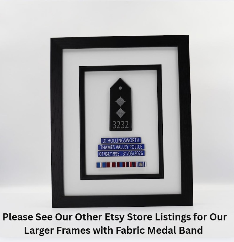 May include: Framed police badge display. The black frame surrounds a white matting, showcasing a black badge with two silver diamonds and the number 3232. Below, a blue nameplate reads "DI HOLLINGSWORTH, THAMES VALLEY POLICE." A ribbon bar with colored stripes completes the display.