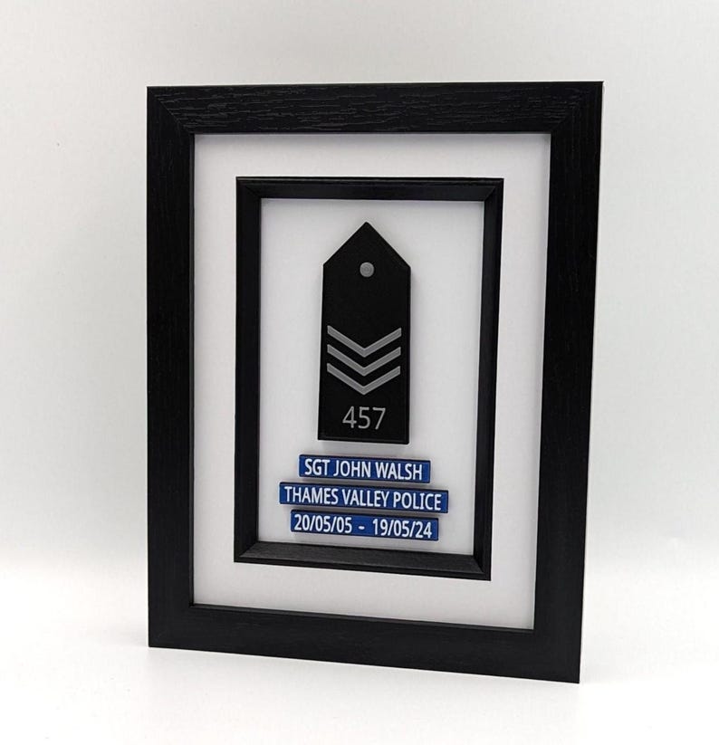 Personalised police presentation frame featuring a black box frame with a mounted UK‑style epaulette and up to three custom plaques in blue or black with white text. A high‑quality, handcrafted display piece ideal for promotions, retirements, new recruits, or celebrating police service.