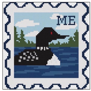 May include: A cross-stitch pattern shaped like a postage stamp featuring a black loon with a red eye swimming on a blue lake. The background shows green pine trees and white clouds in a light blue sky. The letters ME are stitched in the upper right corner.