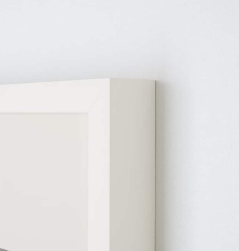 May include: A white picture frame with a white mat. The frame is made of wood and has a simple, modern design.