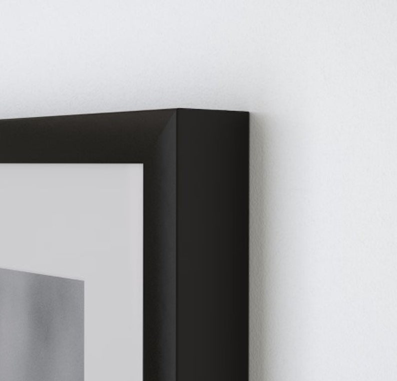 May include: A black picture frame with a white mat. The frame is made of wood and has a simple, modern design.