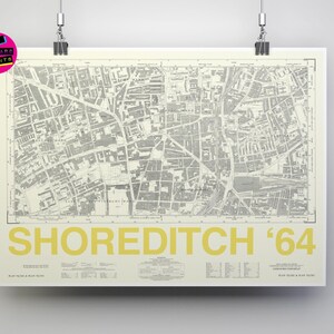 May include: A vintage map of Shoreditch, London, printed in black and white on a cream background. The map shows the streets and buildings of the area in 1964. The title "Shoreditch '64" is printed in yellow at the bottom of the map.