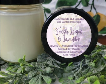 May include: A black candle jar with a white label that reads "Honeysuckle and Lemons The Garden Collection Fresh Lemon & Lavender LEMON + LAVENDER + BERGAMOT Scented Soy Candle Handpoured in Maryland 7.10z/201g".