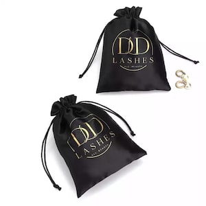 May include: Two black satin drawstring bags with gold lettering that reads "DD Lashes All Beauty".