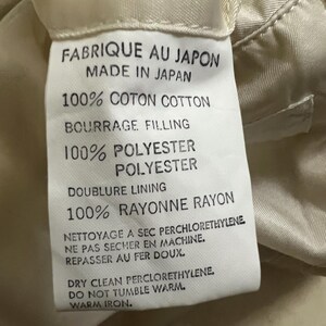 May include: A label with French and English text, including "FABRIQUE AU JAPON MADE IN JAPAN", "100% COTON COTTON", "100% POLYESTER", and "100% RAYONNE RAYON". The label also features care instructions.