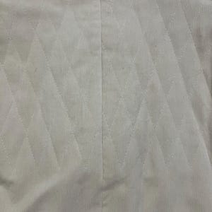 May include: Cream-coloured blazer featuring a diamond pattern. The jacket has a classic collar and a vertical seam at the back. The fabric has a corduroy texture.