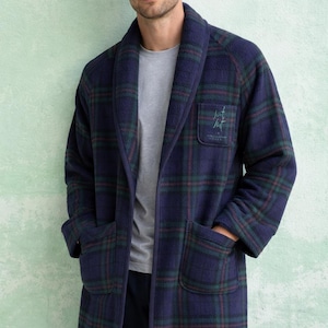 May include: A navy blue plaid robe with green and red accents. The robe has a shawl collar, two front pockets, and a chest pocket with embroidered text. The model is wearing a gray t-shirt underneath.
