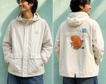 Giacca vintage New Balance beige con cappuccio, antivento, stile Gorpcore, grafica "Spring In the Garden", parka leggero, abbigliamento sportivo.