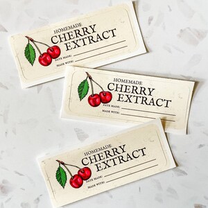 May include: Three blank labels for homemade cherry extract. Each label features a hand-drawn illustration of a cherry branch with two red cherries. The labels have the text "HOMEMADE CHERRY EXTRACT" and spaces for the date made and ingredients.