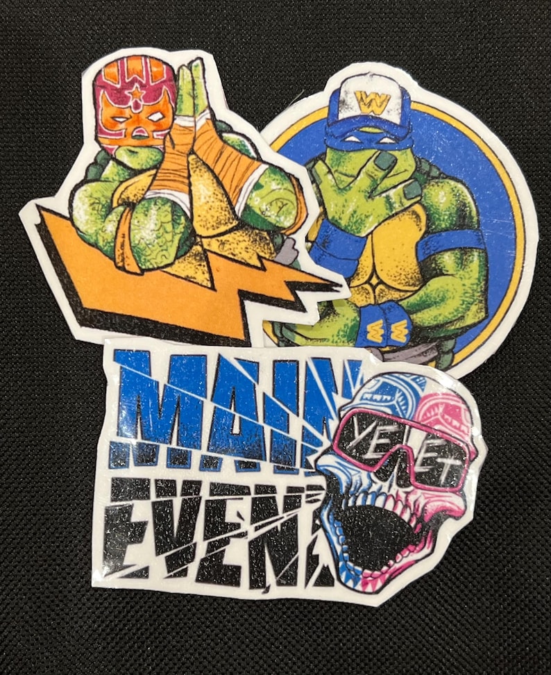 May include: Three colorful iron-on patches featuring Teenage Mutant Ninja Turtles characters. The first patch shows a green turtle wearing a red and orange wrestling mask with a lightning bolt behind him. The second patch shows a green turtle wearing a blue bandana and a yellow baseball cap with the letter W on it. The third patch shows a skull with sunglasses and the word "YET" on it. The patches are all on a black background and have a glittery finish.