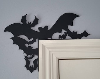 May include: Black metal bat silhouettes in various sizes are arranged in a corner, creating a spooky Halloween decoration.