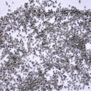 Pode incluir: Um close-up de uma superf&iacute;cie branca coberta de pequenos diamantes cinzentos. Os diamantes est&atilde;o espalhados aleatoriamente pela superf&iacute;cie, criando um efeito brilhante.