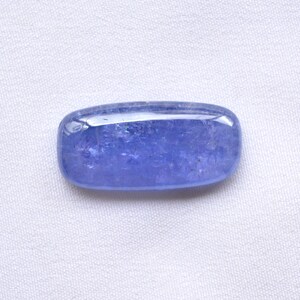 May include: A smooth, light blue gemstone with a rectangular shape. The gemstone has a slightly cloudy appearance.