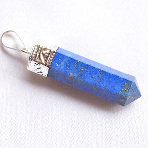 Op de afbeelding: Een blauwe lapis lazuli hanger met een zilveren setting. De hanger is puntvormig en heeft een zilveren lus om aan een ketting te bevestigen.