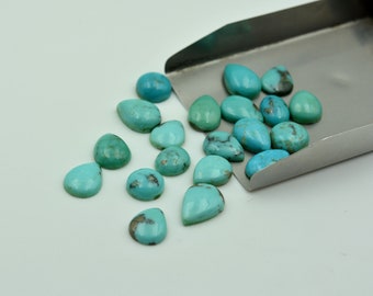 May include: A collection of turquoise cabochons in a teardrop shape. The stones are a vibrant blue-green color and have a smooth, polished finish.