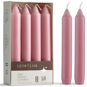 May include: A box of eight pink mini dinner candles with a burn time of 5 hours. The candles are cylindrical with a slightly tapered top and a white wick. The box has the text "LEOR & LAIR" and "Mini Dinner Candles". Each candle is approximately 0.8" x 6".