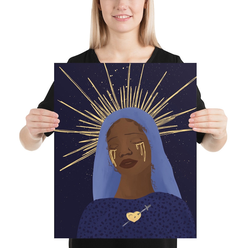 May include: A digital illustration of a woman with dark skin, wearing a blue robe and a gold halo. She has golden tears streaming down her face and a gold heart with a sword through it on her chest. The background is a dark blue with gold stars.