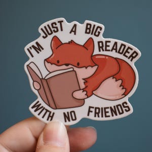 May include: A sticker featuring a cartoon fox reading a book. The fox is orange and white, with the text "I'm just a big reader with no friends" in a white font.