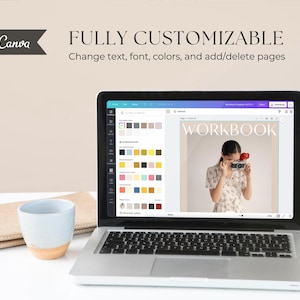 May include: A laptop computer displaying a Canva design template for a workbook. The template features a woman holding a camera and the word "WORKBOOK" in a bold, sans-serif font.