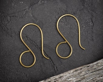 May include: A pair of gold-toned earring hooks. The hooks are made of a thin, smooth metal and have a simple, elegant design.
