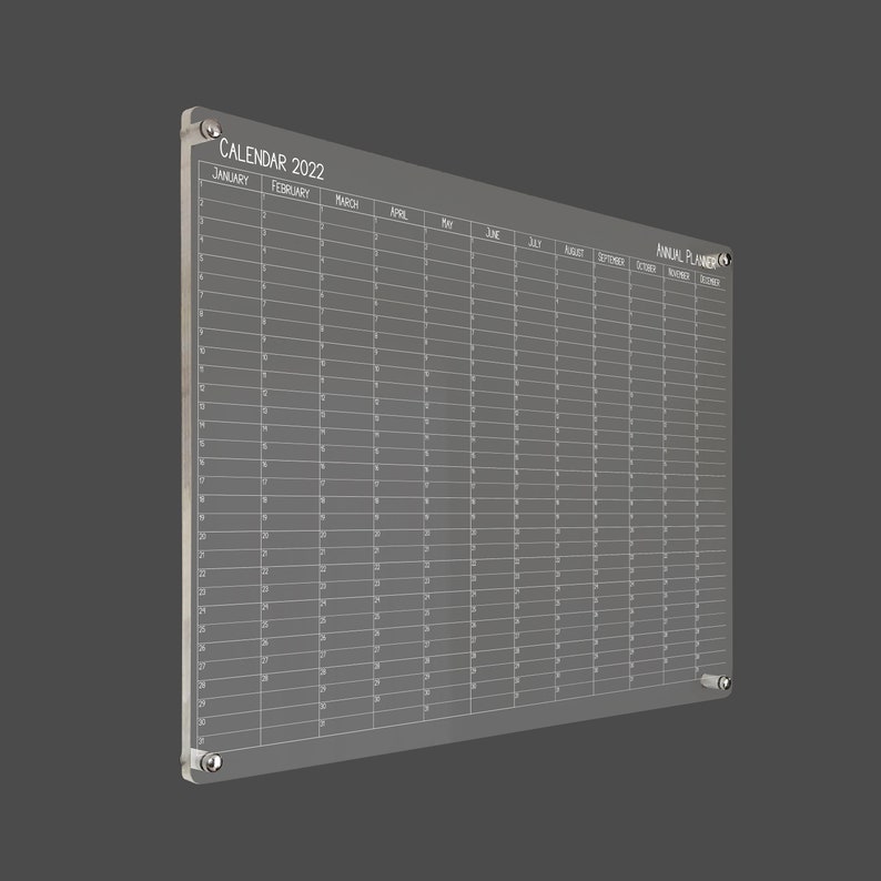 May include: A clear acrylic calendar and planner for the year 2022. The calendar has a grid layout with each month labeled. The planner has a section for each month of the year.