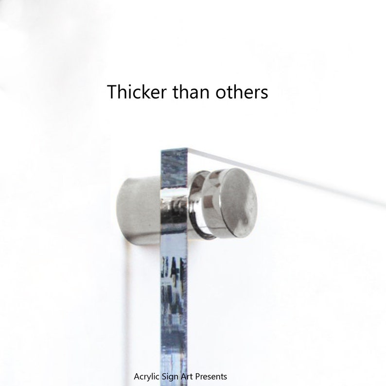 May include: Close-up of a clear acrylic sign with a silver metal stand. The sign is thicker than other signs. The text "Thicker than others" is printed above the sign. The text "Acrylic Sign Art Presents" is printed below the sign.