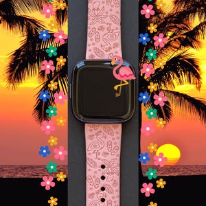K&ouml;nnte beinhalten: Rosafarbenes Apple Watch Armband mit einem Flamingo- und Palmenbaum-Design. Das Armband befindet sich auf einem schwarzen Hintergrund mit einem Sonnenuntergang und Palmen im Hintergrund.