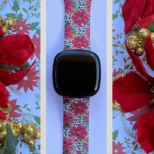 K&ouml;nnte beinhalten: Ein pinkfarbenes und wei&szlig;es Armband mit einem Poinsettien- und Leopardenmuster. Das Armband ist mit einer Smartwatch kompatibel.