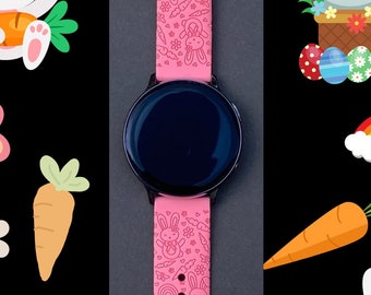 May include: Pink silicone watch band with an Easter theme. The band features a repeating pattern of bunnies, carrots, eggs, and rainbows. The watch face is black with a silver bezel.