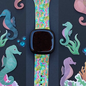 Puede incluir: Una correa de reloj colorida con un patr&oacute;n de caballitos de mar. La correa est&aacute; hecha de silicona y tiene una hebilla negra. La correa est&aacute; decorada con caballitos de mar, conchas marinas y burbujas. La correa de reloj es una excelente manera de agregar un toque de fantas&iacute;a a tu mu&ntilde;eca.