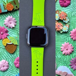 May include: A bright green silicone watch band with palm tree designs. The band is compatible with smartwatches.