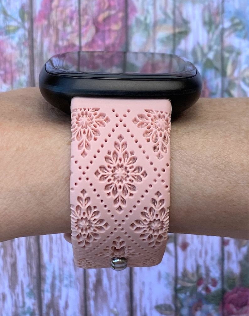 Puede incluir: Una correa de reloj de silicona rosa con un patr&oacute;n floral. La correa est&aacute; dise&ntilde;ada para un reloj inteligente y tiene un cierre de metal.